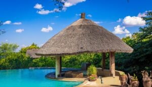 a thatched roof over a swimming pool